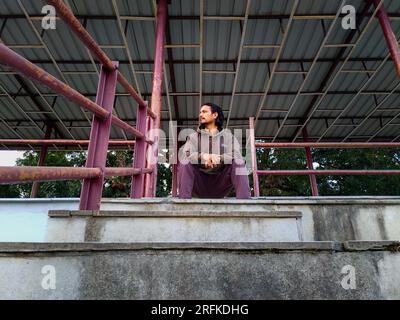 Oktober 14. 2022 Uttarakhand, Indien. Ein junger Indianer sitzt allein auf Stadionständen in Dehradun City, Indien. Ich denke an die Einsamkeit in der leeren Arena. Stockfoto