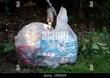 Plastiktüten voller Müll werden vom Community Payback Team vom Gelände eines Sportzentrums entfernt. Stockfoto