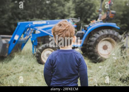 Ein kleiner Junge in Ehrfurcht vor Blue Tractor, Pennsylvania Stockfoto