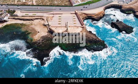 Drohnenansicht von Rabat, Marokko. Felsige Atlantikküste mit Leuchtturm und blauem Wasser Stockfoto