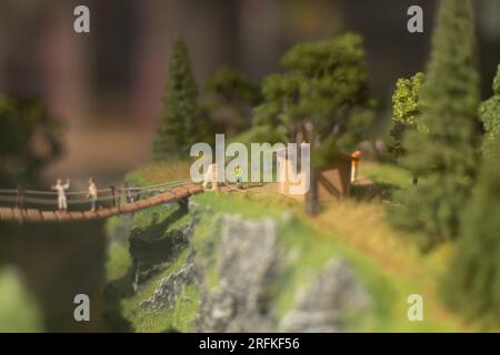 Spielzeugmodell des Parks. Leute auf der Brücke. Bergtouristen im Sommer. Stockfoto