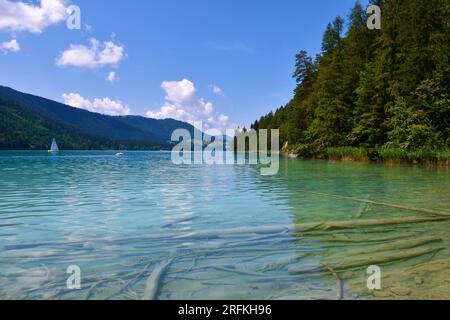 Weissensee in Kärnten oder Kärnten, Österreich mit waldbedeckten Hügeln und Booten auf dem See Stockfoto