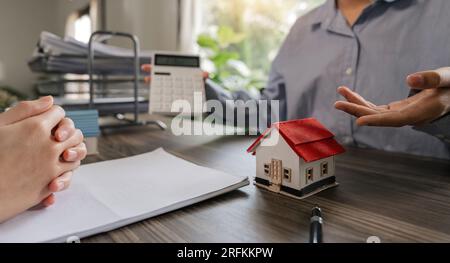 Immobilienmakler im Projekt, um Kunden im Detail zu erklären. Erläutern und präsentieren Sie Informationen über Immobilien- und Hypothekenkäufe. Echt Stockfoto
