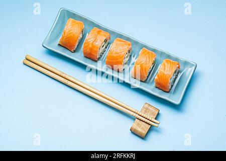 Sushi Roll (Philadelphia) Mit Lachs Und Geräuchertem Aal In Blauer Rechteckiger Platte Stockfoto