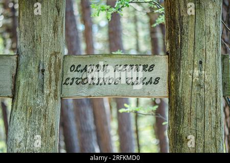 Hölzerne Wegweiser am Eingang zum Olando Kepure Trail inmitten von Hügeln, Dünen und Pinienwäldern an der litauischen Ostsee Stockfoto