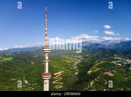 Luftaufnahme der Drohne des Hochfernsehturms von Symbol Almaty City und Park auf dem Koktobe-Hügel vor den Schneebirgen in Kasachstan Stockfoto