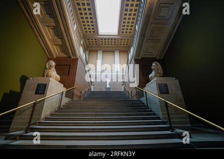 London, England, Großbritannien - 4. August 2022. Das Innere des British Museum in London. Großer Treppeneingang mit antiken Statuen und Museumsschildern, keine Personen. Stockfoto