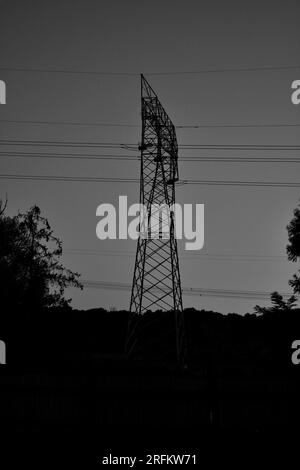 Die markante Silhouette eines elektrischen Pylons bildet einen markanten Blickpunkt. Ein minimalistisches Wunderwerk moderner Infrastruktur. Stockfoto