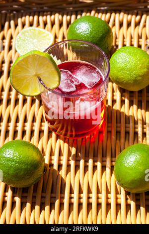 Gläser mit roter Limonade und Eis im Sonnenlicht. Erfrischungsgetränk mit Erdbeercocktail und Sommerbeeren Stockfoto