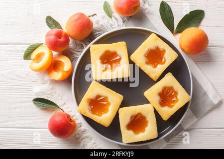 Leckere sommerliche weiche Kekse Cuor di tenerezza mit Aprikosenmarmelade, Nahaufnahme auf einem Teller auf dem Tisch. Horizontale Draufsicht von oben Stockfoto