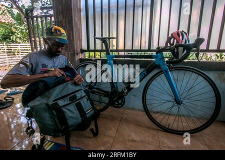 Bogor, Indonesien - 01. August 2023: Kurier in Bogor, West-Java, Indonesien, bereitet Taschen und Fahrräder für die Arbeit vor Stockfoto