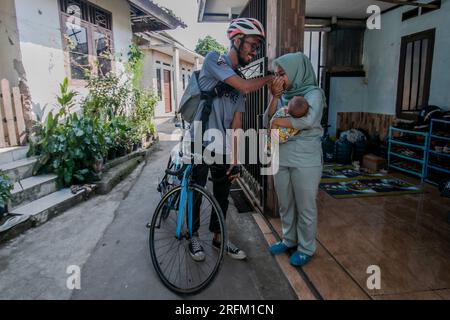 Bogor, Indonesien - 01. August 2023: Ehemann verabschiedet sich von seiner Frau und seinem Baby, um in Bogor, West-Java, zur Arbeit zu gehen. Stockfoto