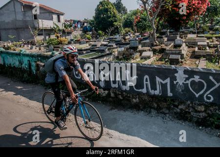 Bogor, Indonesien - 01. August 2023: Radfahrer wandern durch einen Friedhof in Bogor, West-Java. Stockfoto