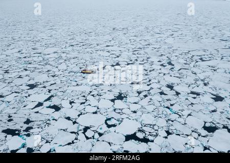 Expeditionsschiff fährt durch Meereis in Svalbard Stockfoto