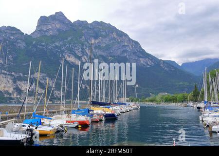 Mai 19 2023 - Riva del Garda in Italien: Menschen am Hafen der Stadt an einem bewölkten Tag Stockfoto