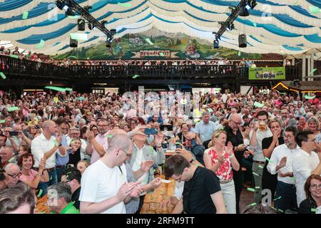 Herne, Deutschland. 04. August 2023. Der Premierminister von Nordrhein-Westfalen, Hendrik Wüst (CDU), kommt zusammen mit Bürgermeister Frank Dudda (SPD) und anderen Würdenträgern, um die Menge und die Darbietungen anzufeuern, und klopft dann das Fass im festlichen Zelt an, um das Cranger Kirmes-Messegelände in Herne offiziell zu eröffnen. Die Cranger Kirmes ist eine der größten in Deutschland. Popsängerin Michelle und andere treten auf. Die beliebte Messe zieht während ihres 10-tägigen Laufs regelmäßig mehr als 4m Besucher an. Die Messe stammt aus dem frühen 18. Jahrhundert in Crange. Kredit: Imageplotter/Alamy Live News Stockfoto