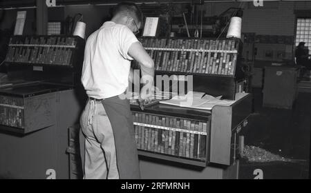 1950er, historischer, männlicher Arbeiter mit einer Leinwand-Schürze bei einer Briefpresse. USA. Name Hamilton Manufacturing auf dem Schrank. Stockfoto