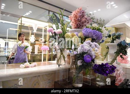 (230804) -- KUNMING, 4. August 2023 (Xinhua) -- Ein Ladenbesitzer arrangiert Blumen in einem Geschäft im Chaoyang District von Peking, Hauptstadt von China, 29. Juli 2023. Yunnan gilt als eines der drei größten Blumenanbaugebiete der Welt. In den letzten Jahren wurden die Pflanz-, Ernte-, Handels-, Transport- und sonstigen Verfahren der Blumenkette Yunnan kontinuierlich verbessert. Livestreamer und Händler beginnen ihre Arbeit am frühen Morgen auf den geschäftigen Blumenmärkten in der Stadt Kunming, umgeben von einem Regenbogen voller Blumen zum Verkauf. In der Kunming International Flora Aucti Stockfoto