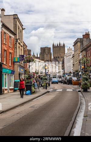 Wells High Street im Stadtzentrum von Wells mit Wells Cathedral im Hintergrund, Wells, Somerset, England, Großbritannien Stockfoto