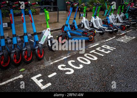 E-Scooter London - E-Scooter in ausgewiesenen Raum in Central London geparkt. Zugelassene E-Scooter zum Mieten in London. Stockfoto