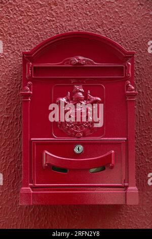 Granada, Spanien - 23. Februar 2022: Rot gefärbter Vintage-Briefkasten an einer Wand in Granada, Spanien. Stockfoto