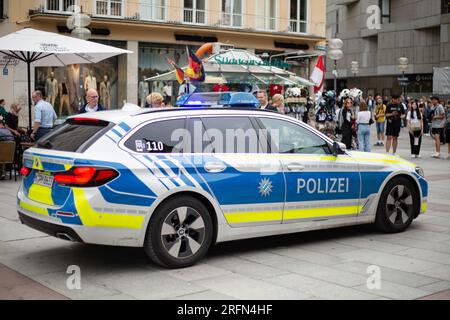 München, Deutschland. 04. Aug. 2023. Polizeiwagen fährt durch die Münchner Fußgängerzone mit blauen Lichtern, während ein Hubschrauber darüber fliegt. (Foto: Alexander Pohl/Sipa USA) Guthaben: SIPA USA/Alamy Live News Stockfoto