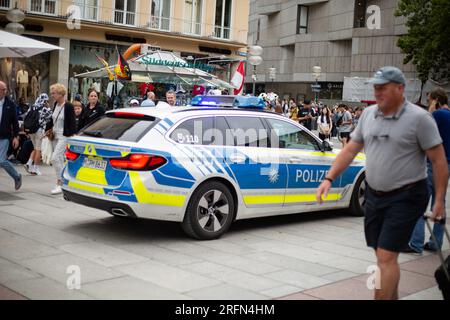 München, Deutschland. 04. Aug. 2023. Polizeiwagen fährt durch die Münchner Fußgängerzone mit blauen Lichtern, während ein Hubschrauber darüber fliegt. (Foto: Alexander Pohl/Sipa USA) Guthaben: SIPA USA/Alamy Live News Stockfoto