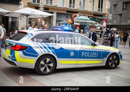 München, Deutschland. 04. Aug. 2023. Polizeiwagen fährt durch die Münchner Fußgängerzone mit blauen Lichtern, während ein Hubschrauber darüber fliegt. (Foto: Alexander Pohl/Sipa USA) Guthaben: SIPA USA/Alamy Live News Stockfoto