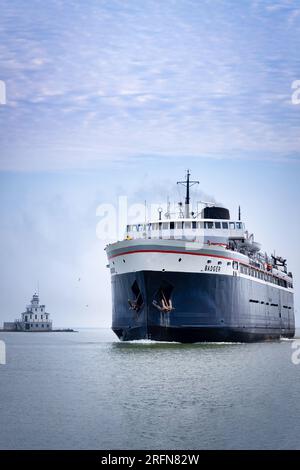 Der SS Badger führt von Ludington, Michigan, am Leuchtturm des North Pier in Manitowoc, Wisconsin vorbei. Stockfoto