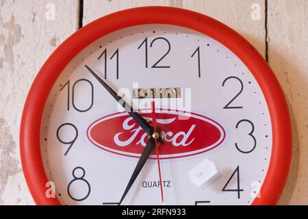 Schilder und Symbole, ein Flohmarkt, eine Wanduhr mit einem Ford-Emblem. Stockfoto