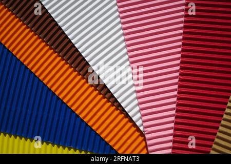 Satz von diagonal gerippten Kartonstücken in den Farben Gelb, Dunkelblau, Orange, Braun, Weiß, Rosa, Rot und Beige. Als Hintergrund gemeint Stockfoto