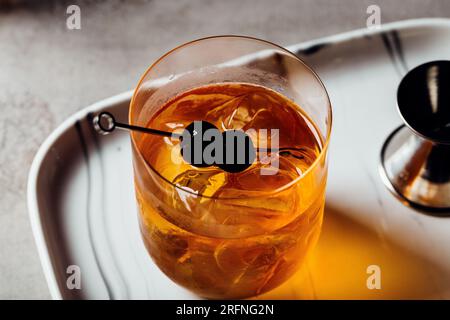 Alkoholisches Manhattan Drink on the Rocks Bourbon Whiskey und garnieren mit Maraschino Kirschen Stockfoto