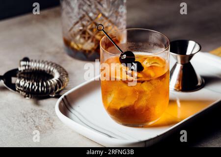 Alkoholisches Manhattan Drink on the Rocks Bourbon Whiskey und garnieren mit Maraschino Kirschen Stockfoto