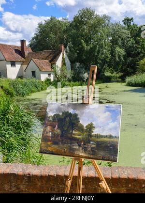 Foto von John Constable's The Hay Wain auf Staffelei, aufgenommen an der gleichen Stelle, an der das Bild gemalt wurde - Flatford, Suffolk, England Stockfoto