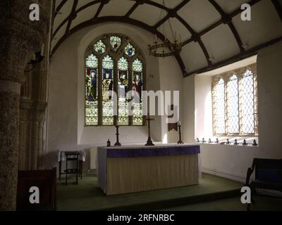 Golant, Cornwall, Großbritannien - 26. März 2022: Altar der St. Sampson's Church. Das Buntglasfenster zeigt Isaiah, Jeremiah, Ezekiel und Daniel. Stockfoto