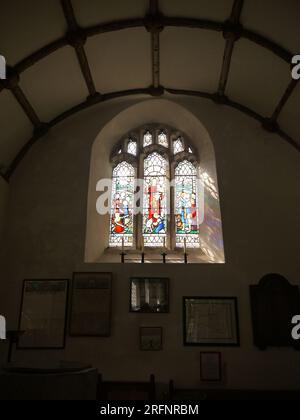 Golant, Cornwall, Großbritannien - 26. März 2022: Buntglasfenster über der Schrift in der St. Sampson's Church, zum Gedenken an Amelia Ellen Blowey. Stockfoto