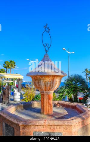 Villajoyosa, Spanien, mittelalterlicher Brunnen aus altem Stein. Das im Hafenviertel gelegene Skulpturengebäude ist ein Wahrzeichen der Region. Stockfoto