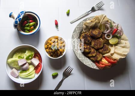 Blick von oben auf die indische Street Food Zutat chole und Tiki Kebab oder Kichererbsen Masala. Stockfoto