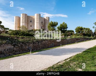 ANDRIA, ITALIEN - 30. OKTOBER 2021: Landschaft mit Castel del Monte bei schönem Sonnenuntergang mit Schotterpfad Stockfoto