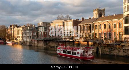 YORK, YORKSHIRE, Großbritannien - 13. MÄRZ 2010: Yorkboat-Bootstour mit Bootstouren vorbei an sonnenbeschienenen Gebäuden am Fluss Ouse Stockfoto