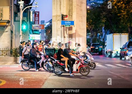 Motorräder und Mopeds warten an einer Verkehrskreuzung im geschäftigen Stadtzentrum von Silom in Bangkok City, Thailand. Stockfoto