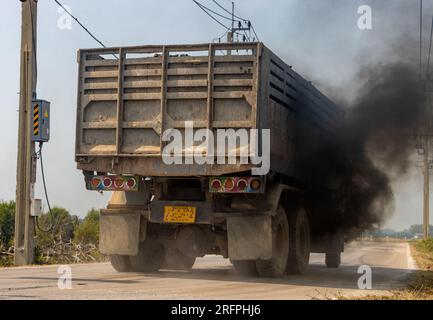 Ein beladener LKW fährt mit dickem schwarzen Rauch vom Auspuff auf die Straße Stockfoto