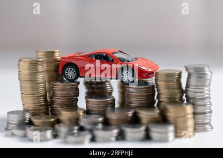 Draufsicht des Miniaturautos, Taschenrechner und Stift auf dem Bürotisch. Geschäfts-, Finanz-, Sparungs-, Bank- oder Autokredite. Auto, Münzen und Stockfoto