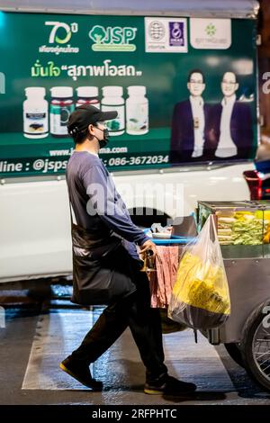 Ein thailändischer Obstverkäufer macht sich auf den Weg entlang der Silom Road In der geschäftigen Innenstadt von Silom, Bangkok City, Thailand. Stockfoto