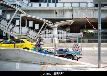 Ein klassisches thailändisches Tuk-Tuk steht vor der Chong Nonsi BTS Sky Station in der Chong Nonsi Gegend von Bangkok City, Thailand. Stockfoto