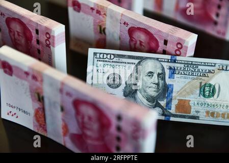 China. 05. Aug. 2023. In dieser Abbildung werden in einer Tabelle 100 US-Dollar-Scheine und 100 RMB-Notizen angezeigt. Kredit: SOPA Images Limited/Alamy Live News Stockfoto