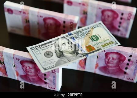 China. 05. Aug. 2023. In dieser Abbildung werden in einer Tabelle 100 US-Dollar-Scheine und 100 RMB-Notizen angezeigt. Kredit: SOPA Images Limited/Alamy Live News Stockfoto