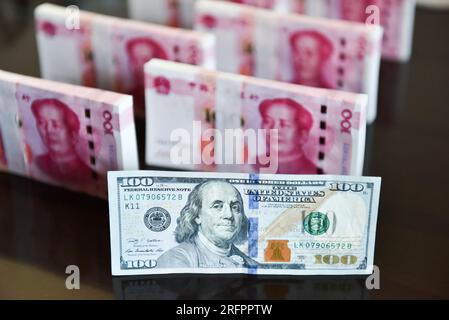 China. 05. Aug. 2023. In dieser Abbildung werden in einer Tabelle 100 US-Dollar-Scheine und 100 RMB-Notizen angezeigt. Kredit: SOPA Images Limited/Alamy Live News Stockfoto