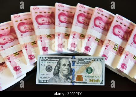 China. 05. Aug. 2023. In dieser Abbildung werden in einer Tabelle 100 US-Dollar-Scheine und 100 RMB-Notizen angezeigt. Kredit: SOPA Images Limited/Alamy Live News Stockfoto