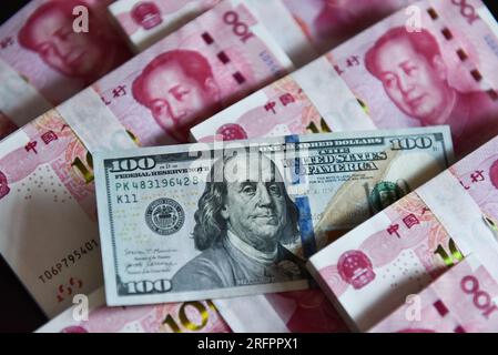 China. 05. Aug. 2023. In dieser Abbildung werden in einer Tabelle 100 US-Dollar-Scheine und 100 RMB-Notizen angezeigt. Kredit: SOPA Images Limited/Alamy Live News Stockfoto